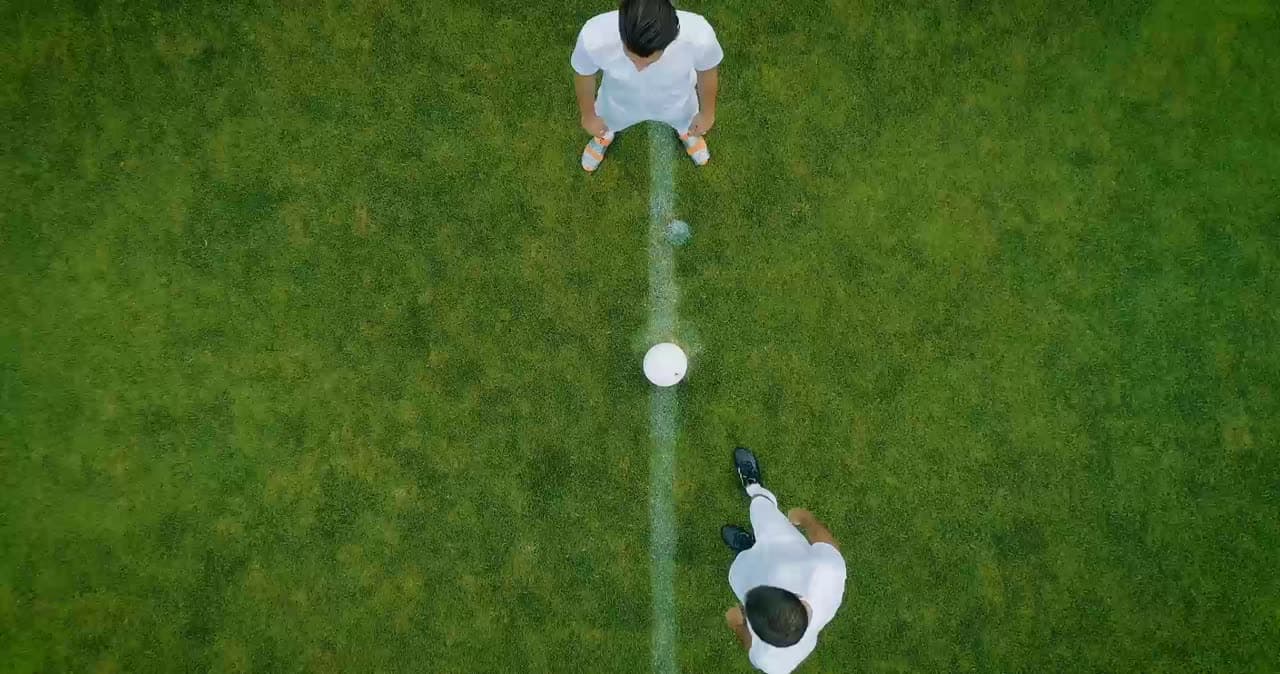 Fußballfeld von oben mit zwei Spielern am Anstoßpunkt